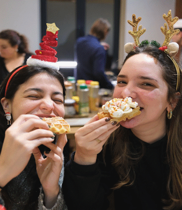 girls eating waffles at the Bruges Waffle Making Activity in Bruges Belgium